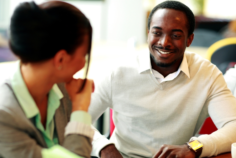 An African American man being interviewed by a woman with her back to the camera.